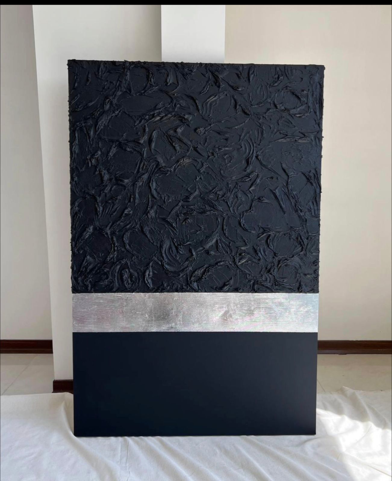Black textured artwork with a horizontal silver stripe